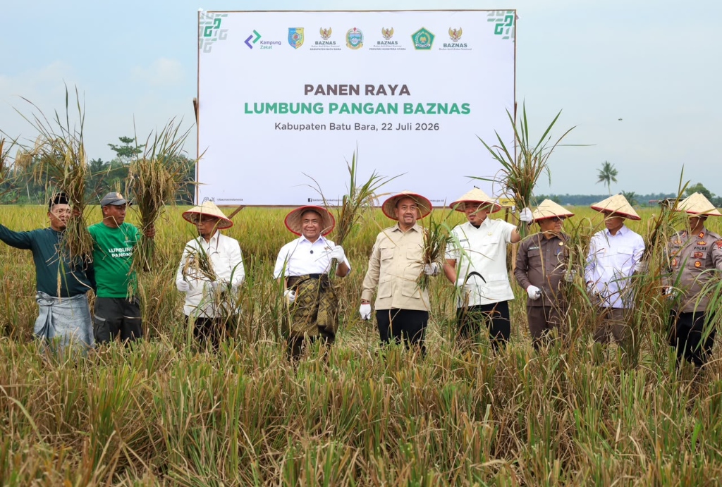 Ketua BAZNAS RI dan pejabat pemda memegang padi saat Panen Raya Lumbung Pangan BAZNAS di Desa Kwala Gunung, Kabupaten Batu Bara.