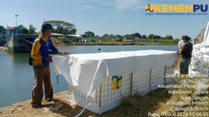 Petugas memasang material sandbag sebagai penanganan darurat di Bendung Karet Welahan Bum, Kabupaten Jepara, Jawa Tengah.